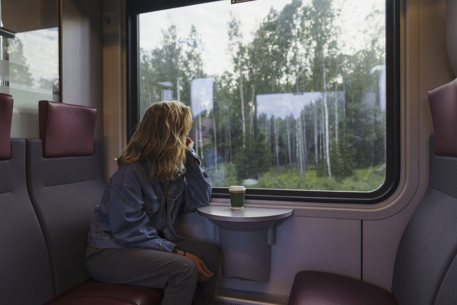 Woman traveling by train looking out of window