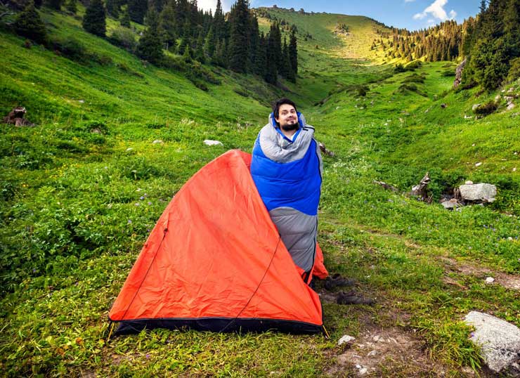 camper waking up in sleeping bag