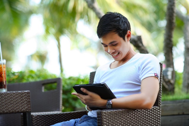 man in white shirt using tablet computer shallow focus 207582