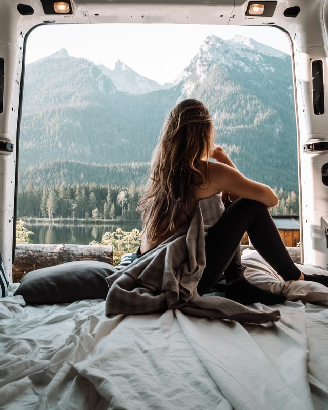 woman in the back of a van looking at mountains 4171211