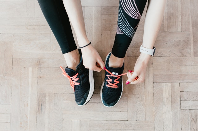 crop young sportswoman tying sneakers on floor 4498570