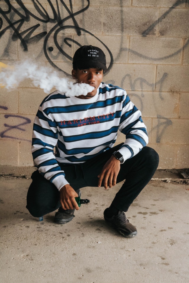 man in blue and white striped sweater smoking cigarette 3958284